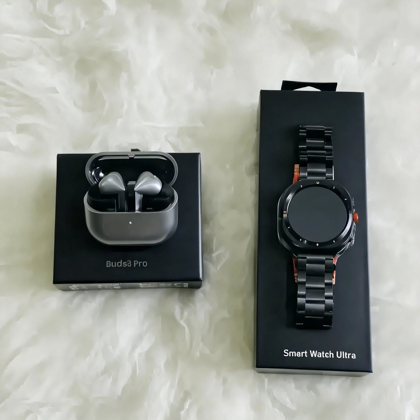 Open Samsung Smart Watch Ultra and Samsung Galaxy Buds 3 Pro earbuds from ELLORA TECH, with the watch face visible on the screen.