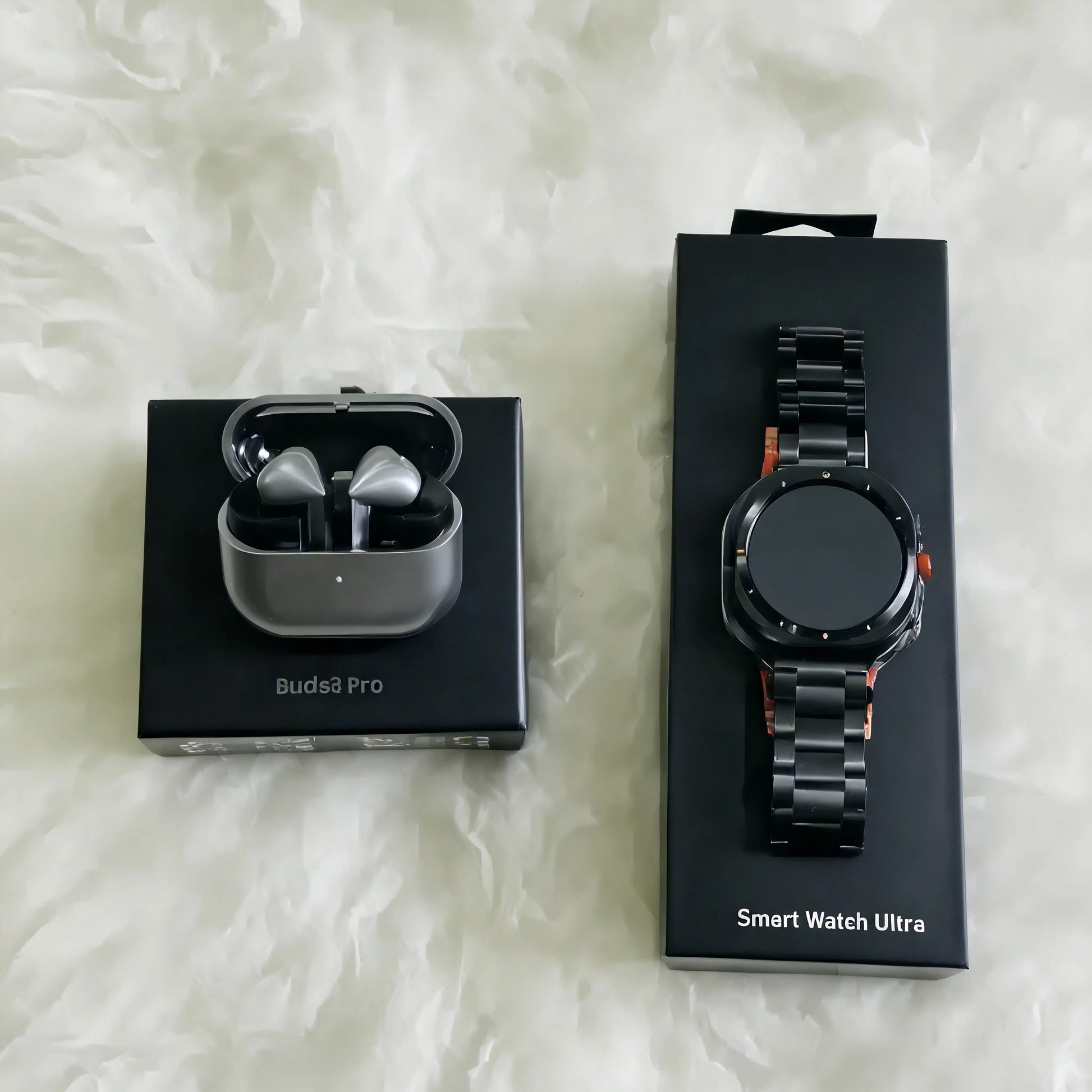 Open Samsung Smart Watch Ultra and Samsung Galaxy Buds 3 Pro earbuds from ELLORA TECH, with the watch face visible on the screen.